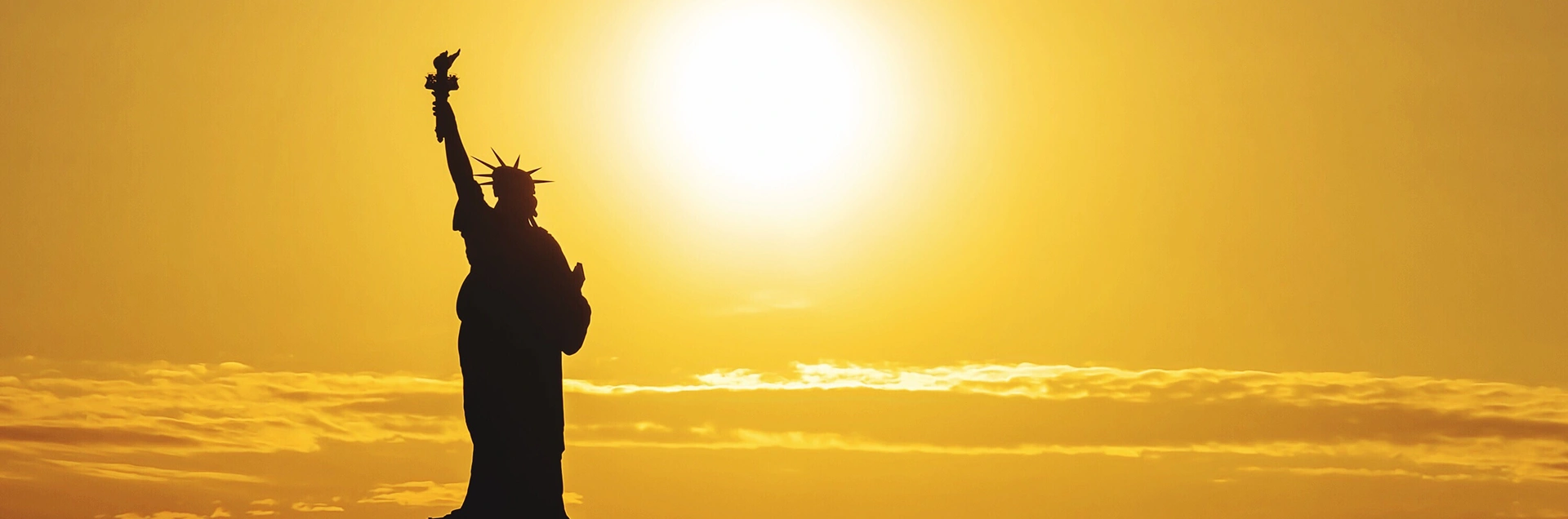 Statue of Liberty against the backdrop of the sun